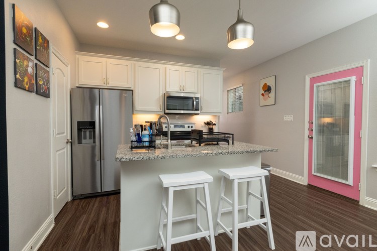 A kitchen with white cabinets and a granite countertop.