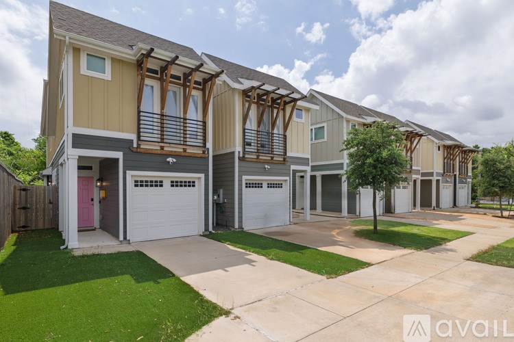 A row of houses with the first one having a pink door.