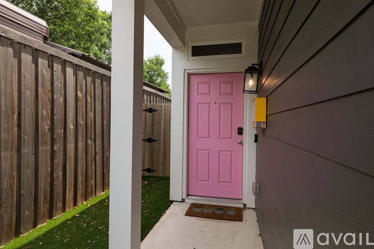 A pink door is the only entrance to a house.