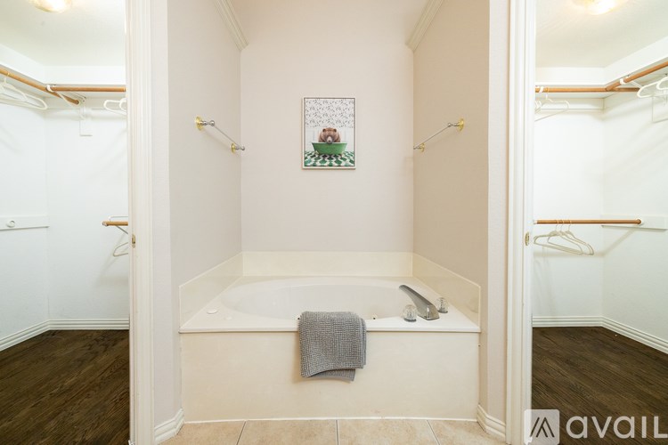 A bathroom with a white tub and a picture of a Christmas tree on the wall.