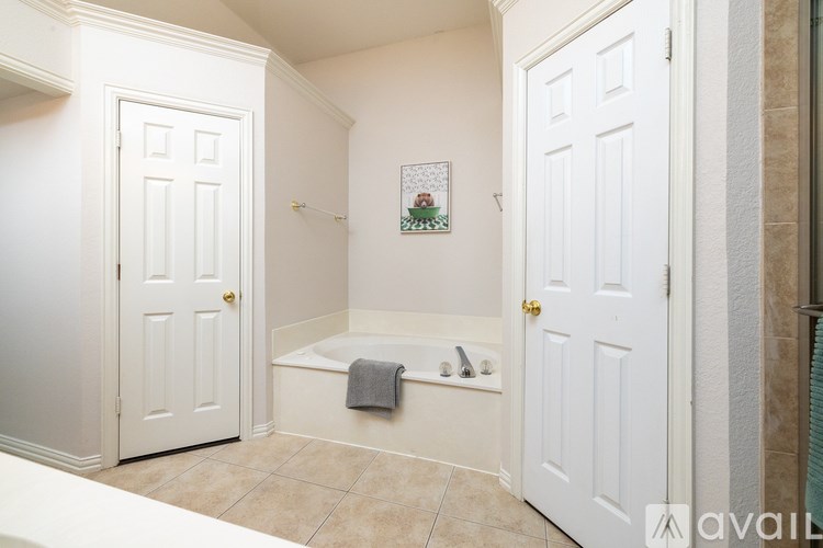 A bathroom with a white tub and towels.