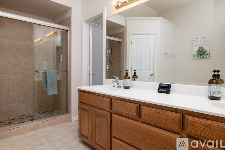 A bathroom with a wooden vanity and a glass shower area.