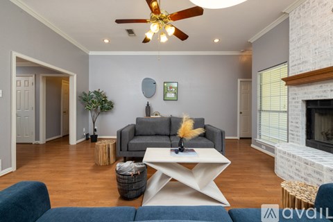 A living room with a grey couch and a white coffee table.