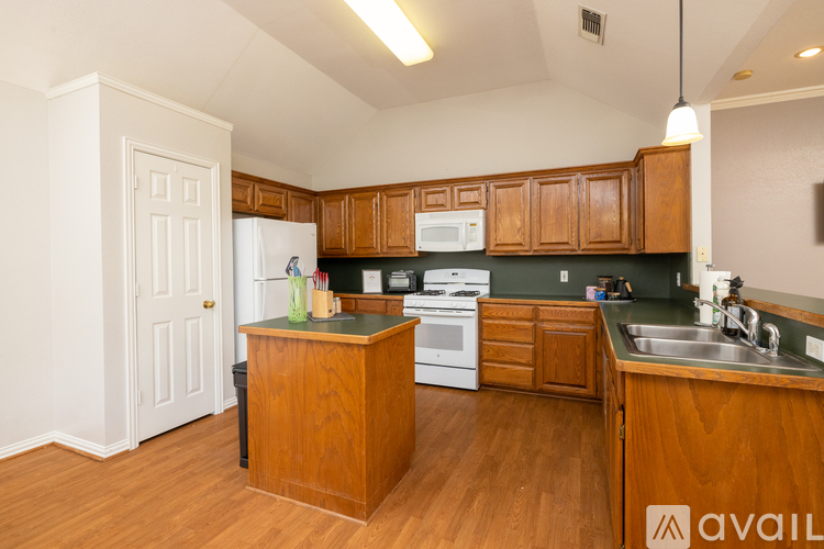 A kitchen with wooden cabinets and a white refrigerator.
