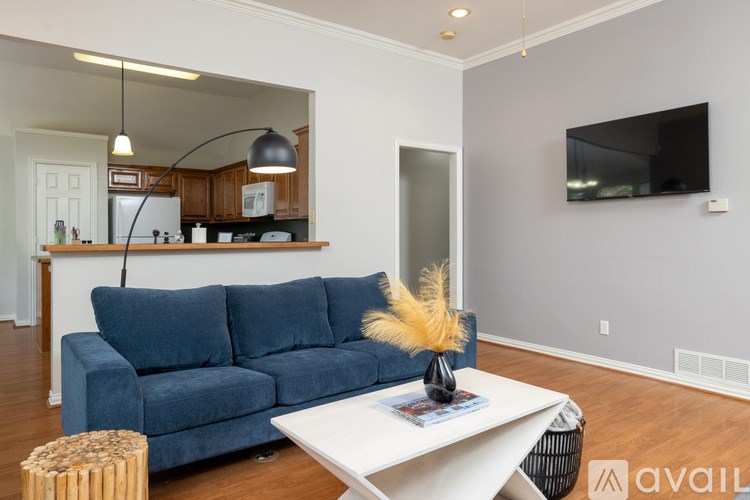 A living room with a blue couch and a white coffee table.