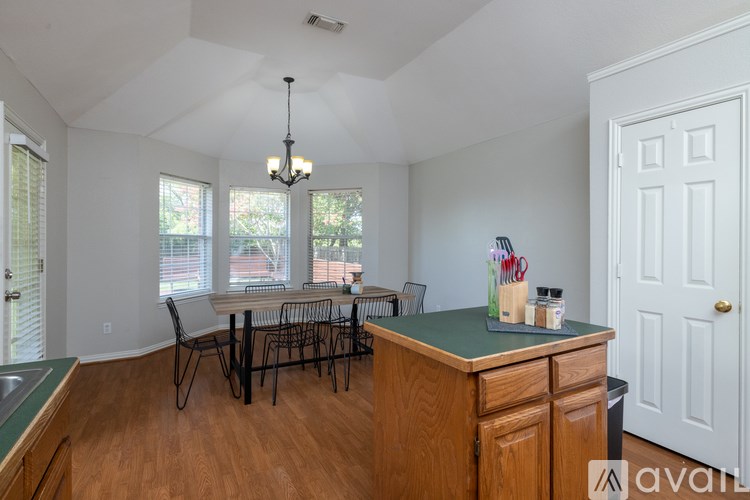 A kitchen with a table and chairs in front of a window.