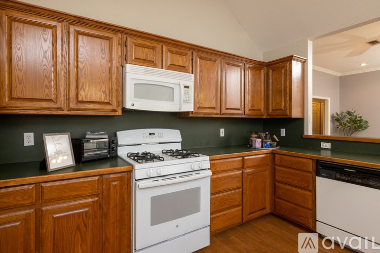 A kitchen with wooden cabinets and a white stove top oven.