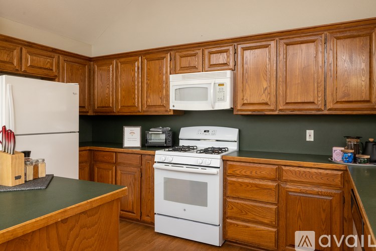 A kitchen with wooden cabinets and a white stove top oven.