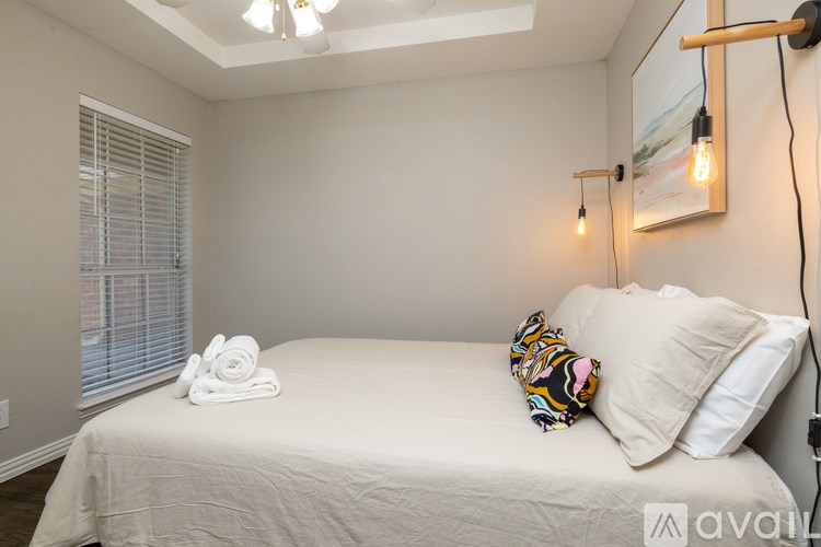 A bedroom with a bed, pillows, and a window with blinds.