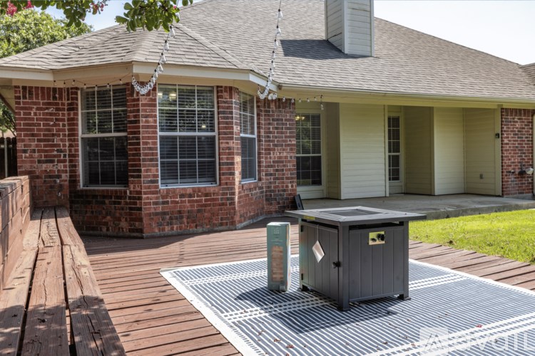 A brick house with a grill on the backyard.