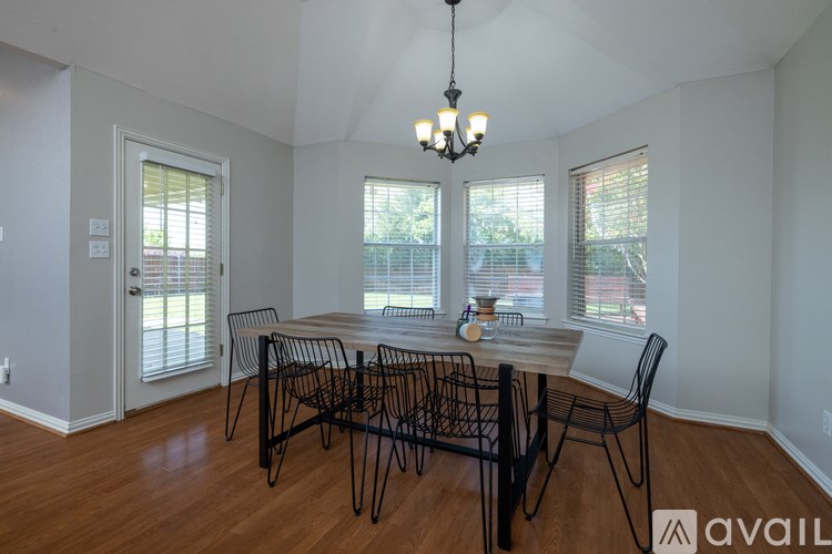A dining room with a table and chairs.
