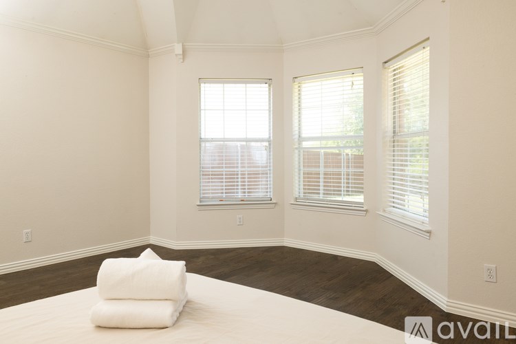 A bedroom with a large bed and two windows.