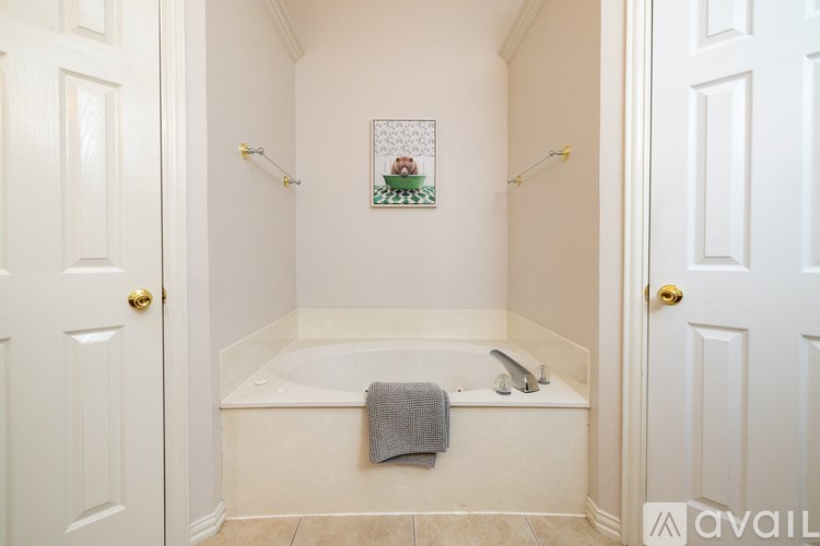 A bathroom with a white tub and a picture of a Christmas tree on the wall.