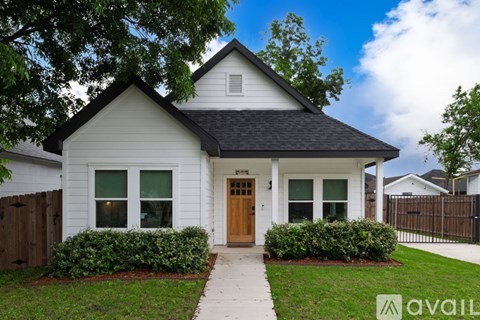 A small white house with a brown door and windows.