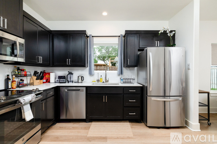 A kitchen with black cabinets and stainless steel appliances.