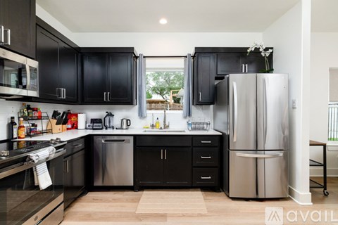 A kitchen with black cabinets and stainless steel appliances.