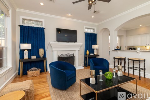 A living room with a blue chair and a black coffee table.