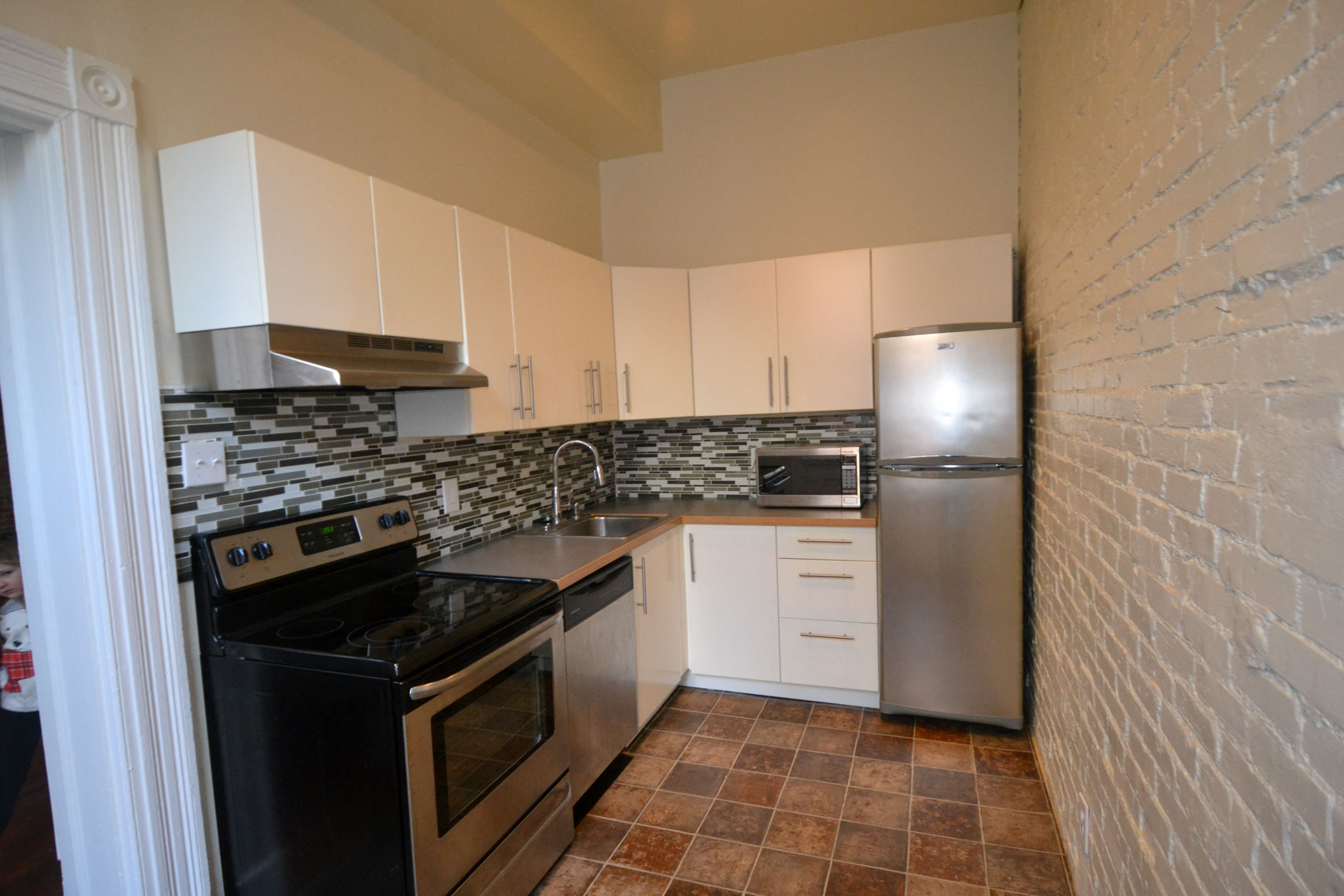 a kitchen with stainless steel appliances and white cabinets
