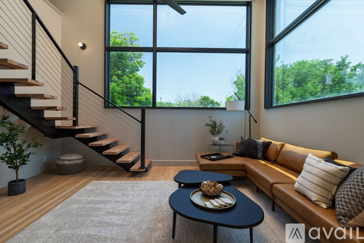 A living room with a couch, coffee table, and staircase.
