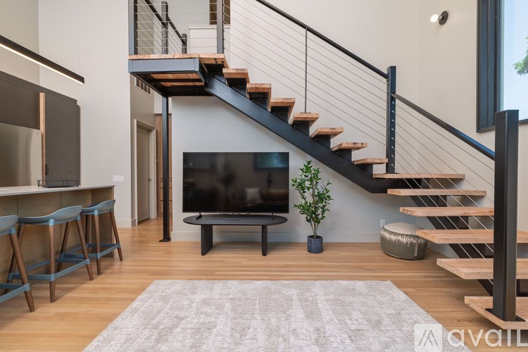 A living room with a television and a staircase.