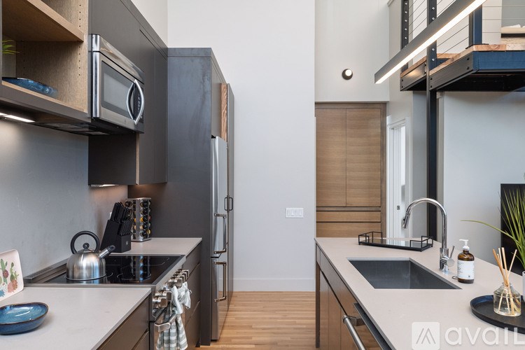 A modern kitchen with a stainless steel refrigerator and a microwave above the stove.