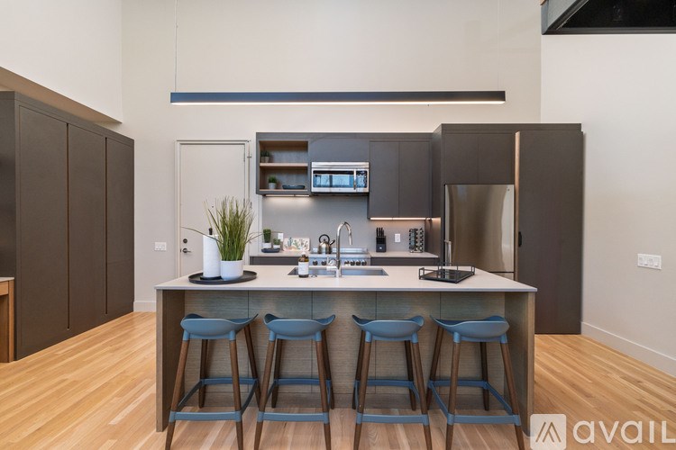 A modern kitchen with a bar stool in front of the island.