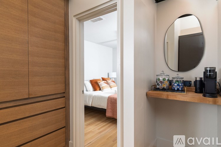 A bedroom with a bed, a mirror, and a shelf with various items.