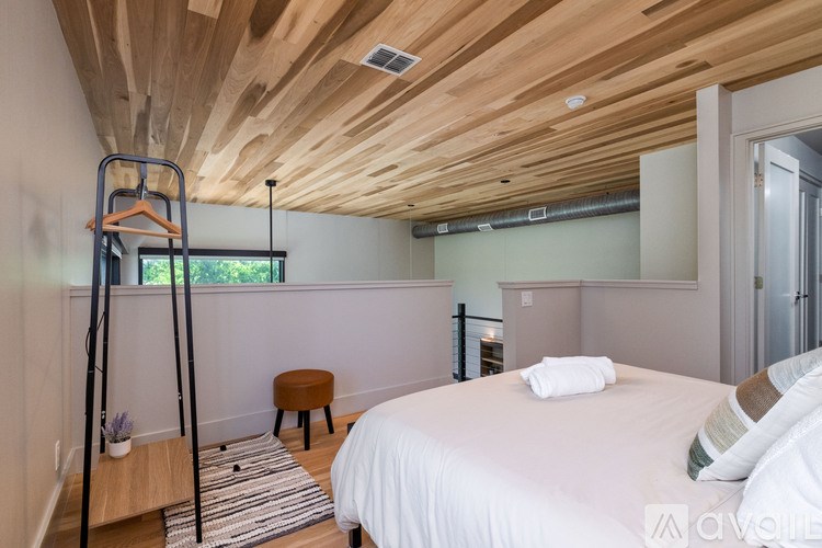A bedroom with a wooden ceiling and a white bed.