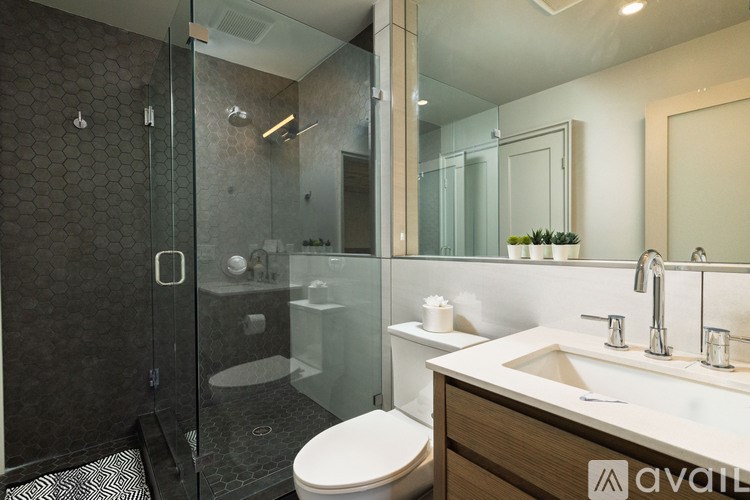 A modern bathroom with a walk-in shower and double sink vanity.