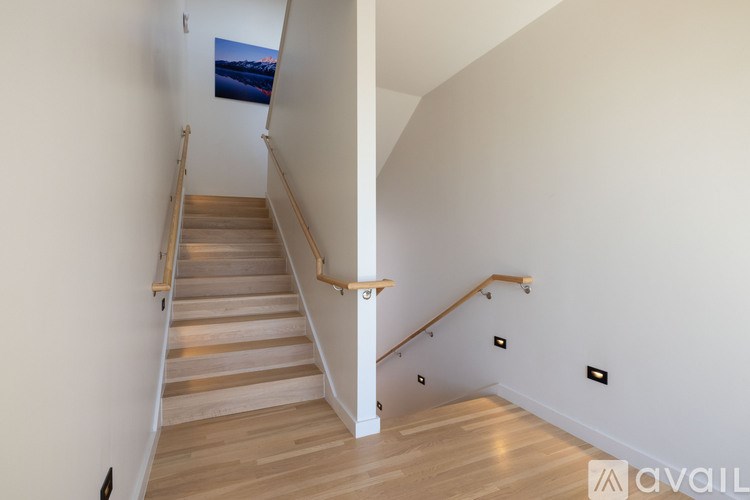 A wooden staircase with a railing leads up to a landing.