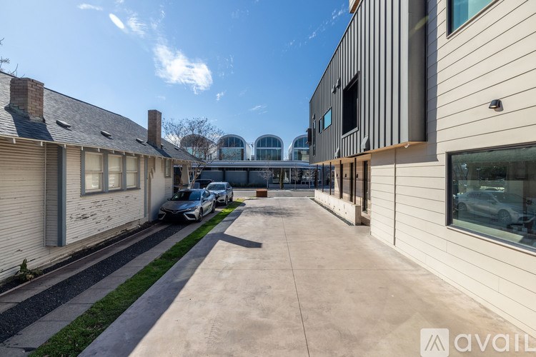 A sunny day at a modern building with cars parked outside.