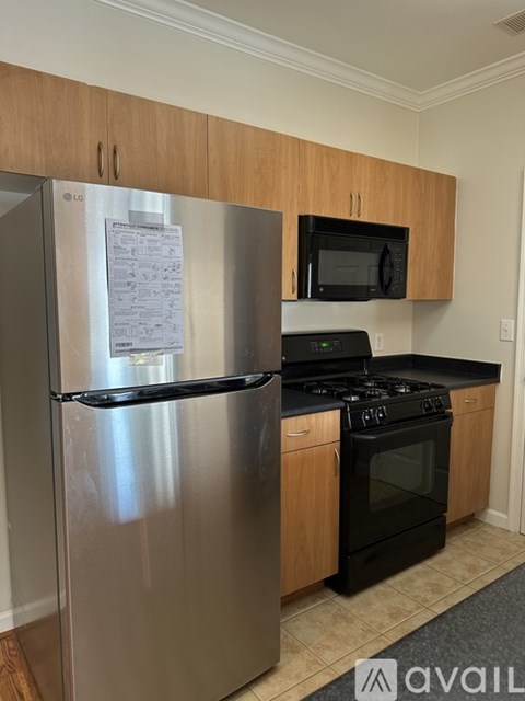 A kitchen with a stainless steel refrigerator and black stove top oven.