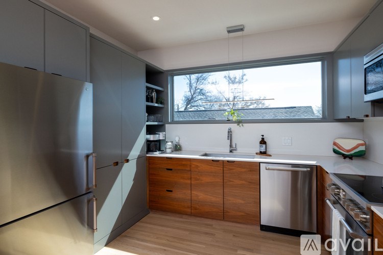 A kitchen with a stainless steel refrigerator and wooden cabinets.