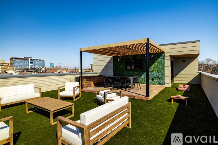 A modern outdoor seating area with a wooden pergola and green wall.