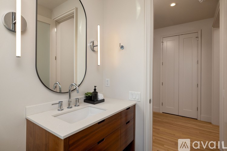 A bathroom with a sink, mirror, and wooden cabinets.