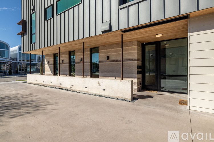 A modern building with a white facade and a wooden beam running along the side.