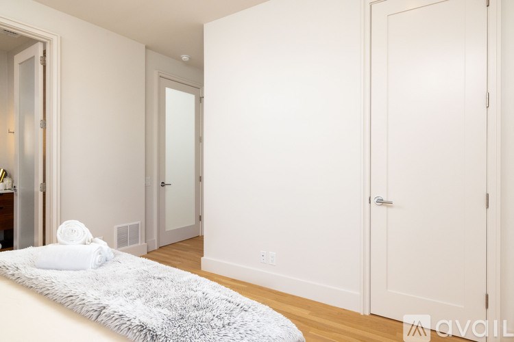 A bedroom with a bed, a rug, and a door.