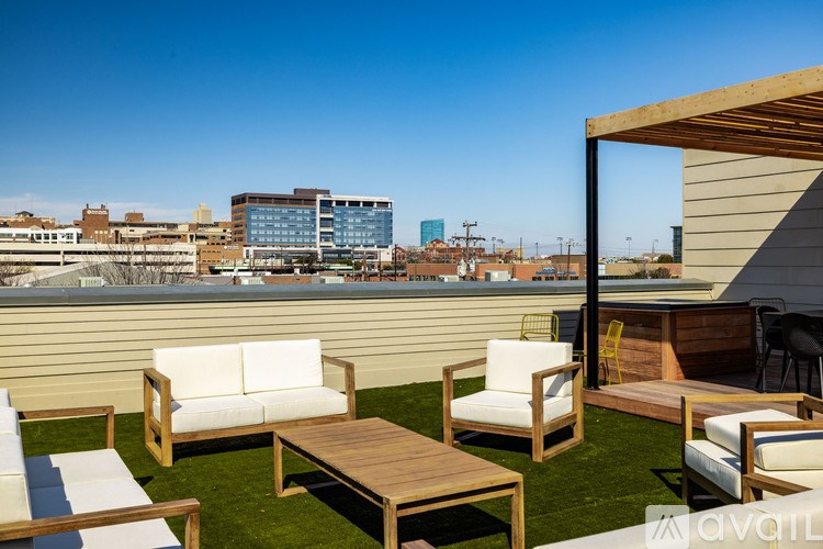 A patio with white cushioned furniture and a wooden table.