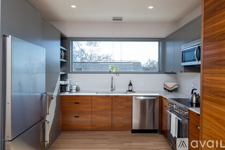 A modern kitchen with wooden cabinets and stainless steel appliances.
