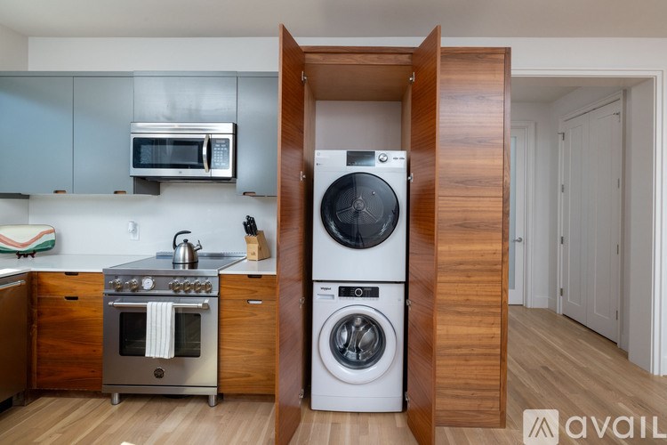 A modern kitchen with a washing machine built into the cabinetry.