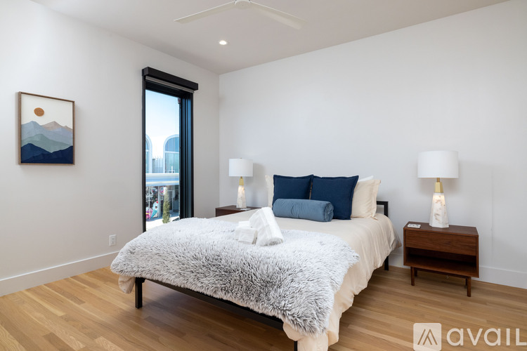 A bedroom with a large bed and a painting on the wall.