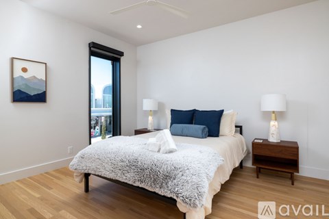 A bedroom with a large bed and a painting on the wall.