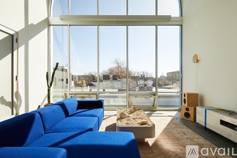 A living room with blue sofas and a large window.