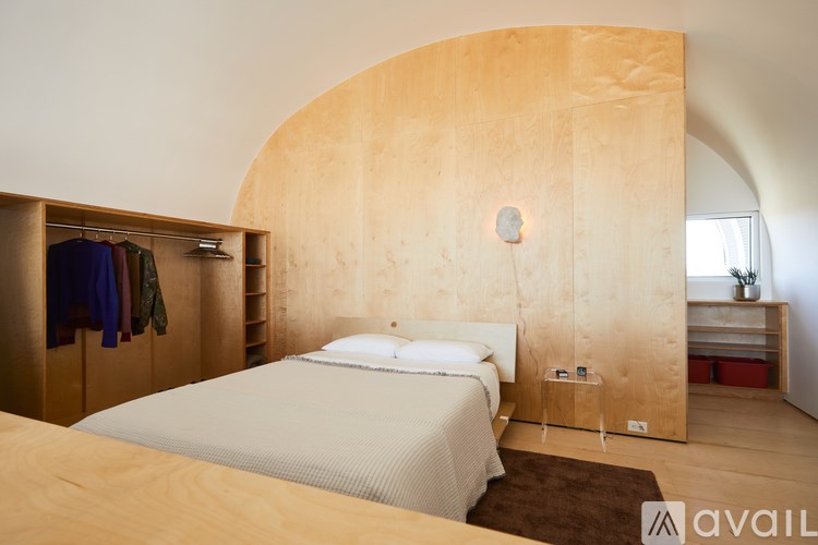 A bedroom with a large bed and a wooden headboard.