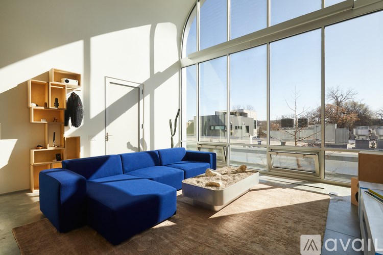 A blue sofa in a room with a lot of windows.