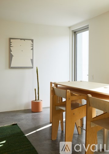A room with a table and chairs and a picture on the wall.