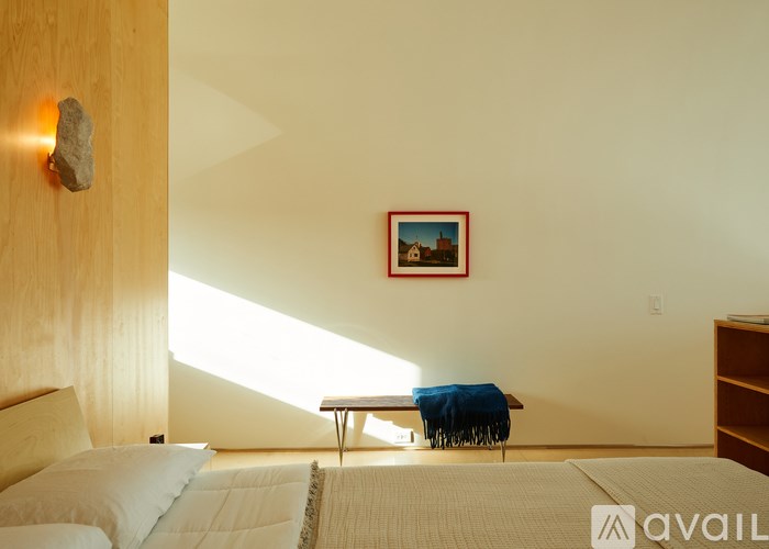 A bedroom with a bed, a nightstand, and a picture on the wall.