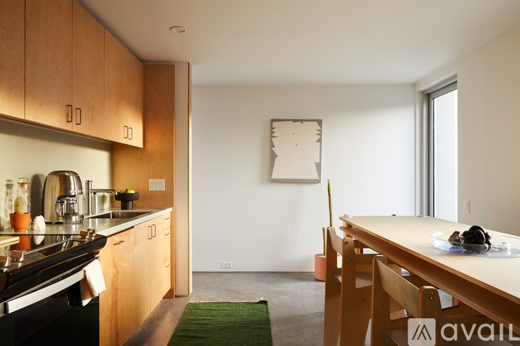 A kitchen with wooden cabinets and a green rug on the floor.