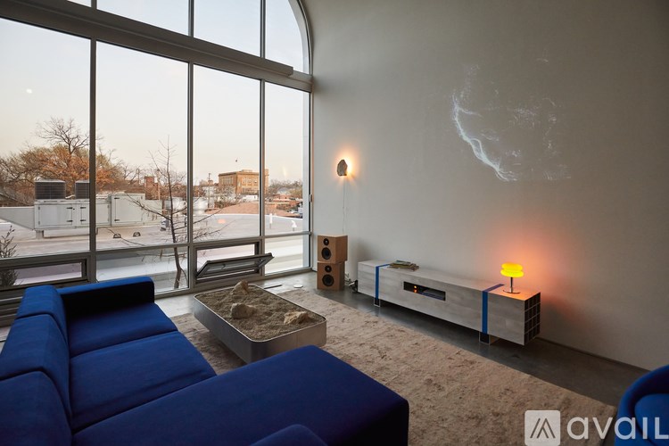 A blue couch sits in front of a large window in a modern living room.