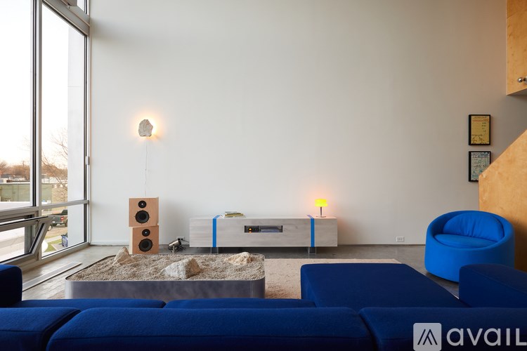 A living room with a blue sofa and a speaker system.